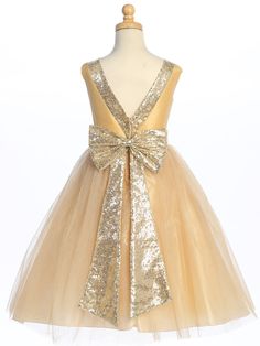 Details Lovely gold colored dress for the holidays or a very special flower girl! Shantung bodice with sparkle tulle skirt V-back with sequins trim and bow Tea length Zipper back closure Made in U.S.A. Available in the following sizes: 2T, 3T, 4T, 5, 6, 7, 8 and 10 Made in the USA by Lito Childrens Wear Gold Sequin Dress With Contrast Detail For Wedding, Gold Embellished Tulle Dress, Gold Princess Tulle Pageant Dress, Gold Tulle Princess Pageant Dress, Gold Fitted Pageant Dress For Party, Gold Embellished Princess Dress, Gold Fitted Pageant Party Dress, Elegant Gold Princess Dress For Party, Gold Sequined Princess Dress For Party