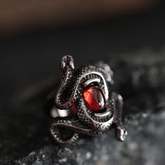 Enter the mystique with our Double Snake Ruby-Style Red Stone Gothic Ring--a mesmerizing fusion of gothic allure and intricate design. Crafted from durable stainless steel, this ring features two snakes coiled around a captivating ruby-style stone, creating a bewitching symbol of transformation and mystery.  Perfect for the woman who adores the enigmatic, this ring is not just an accessory but an extraordinary present that speaks volumes about her unique style and untamed spirit. -- Shipping inf Gothic Style Jewelry Metal Ring As Gift, Black Fantasy Rings As Gift, Black Fantasy Style Rings As Gift, Fantasy Style Black Ring For Gift, Red Rings For Halloween Gift, Halloween Stainless Steel Ring Jewelry, Gothic Stainless Steel Metal Ring Jewelry, Red Ring Jewelry For Halloween, Red Fantasy Metal Jewelry