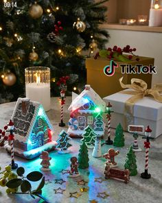 a christmas scene with gingerbread houses, candy canes and candles on the table