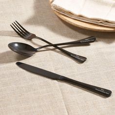 three forks and two spoons sitting next to each other on top of a table