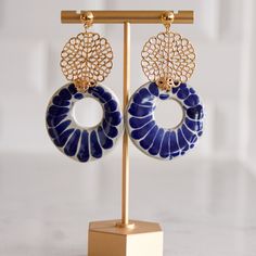 These minimalist and elegant, one of a kind drop earrings were created by joining the traditional and vibrant Talavera from Puebla and adding the finishing touch of our talented artisan partner from Mexico City. The fusion of these two talents creates a modern, bohemian and versatile piece of wearable art. Perfect for everyday wear, special occasions or as a gift for that special someone in your life. These statement earrings are embellished with 14K gold plated circular motifs. They are 2.5"in Artisan Blue Earrings, Artisan Handmade Blue Earrings, Handmade Artisan Blue Earrings, Artisan Blue Drop Earrings, Artisan Blue Earrings With Artistic Design, Bohemian Blue Earrings With Artistic Design, Blue Bohemian Earrings With Artistic Design, Artisan Blue Hand Painted Jewelry, Blue Hand Painted Dangle Jewelry