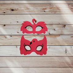 two red masks are sitting on a wooden surface