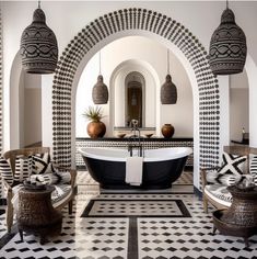 a bathroom with black and white tiles on the floor, an oval bathtub in the center