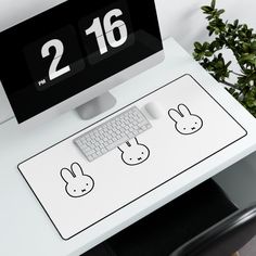 a white desk with a keyboard and mouse on it next to a potted plant