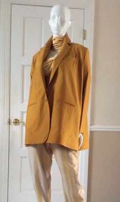 The jacket has a lot of body. The hem is structured with a stiff inner lining so that the jacket stands away from the body. This iconic shape of Romeo Gigli’s is a signature style. The lapel is notched and falls to the waistline. There is a boutonniere button hole in the lapel. The jacket has a working breast pocket, two front pickets, and two working interior menswear style pockets. Unlined, except for the sleeves. Gold Blazer For Office In Spring, Gold Spring Blazer For Office, Chic Gold Blazer For Fall, Chic Gold Long Sleeve Blazer, Gold Single-breasted Winter Blazer, Gold Single Breasted Blazer For Winter, Gold Single-breasted Blazer For Winter, Gold Single-breasted Blazer, Winter Gold Single Breasted Blazer