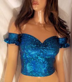 a female mannequin wearing a blue top with sequins