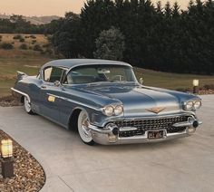 an old classic car parked in a driveway