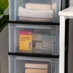 two clear storage containers filled with books and papers