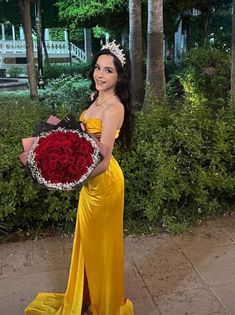 a woman in a yellow dress holding a bouquet of roses and wearing a tiara