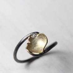 Cup of Luck is an adorably romantic diamond ring. If you are into symbolism and could use a lucky streak this might be for you! Subtle yet striking it was handmade from sterling silver and 14k yellow gold. The chalice shaped flower petal contains one flush set 1.5mm diamond (G color, VS quality). The cup measures 10-11mm in diameter. Size 6.5 or 53.5 or 17 or M 1/2 nangijalajewelry.etsy.com One Of A Kind *Please note: The deep black oxidation will wear off over time. You are welcome to send your Flower-shaped Diamond Ring With Accents As Gift, Flower Shaped Diamond Ring With Accents For Gift, Flower Shaped Diamond Ring With Accents, Flower Shaped Diamond Ring With Diamond Accents, Flower-shaped Rings With Diamond Accents For Gifts, Silver Jewelry With Single Diamond For Proposal, Silver Diamond Jewelry For Proposal, Hand Forged Diamond Promise Ring, Hand Forged Diamond Rings For Promise