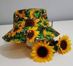 the sunflowers are sitting on the table next to the hat and two flowers