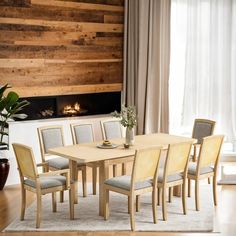 a dining room table with six chairs and a fireplace in the back wall behind it