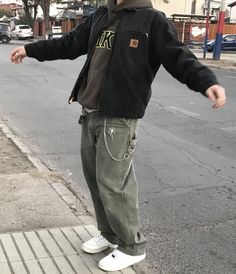 a young man standing on the side of a street