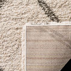 an area rug on the ground with a black cat laying next to it