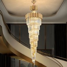 a large chandelier hanging from the ceiling in a living room next to a spiral staircase