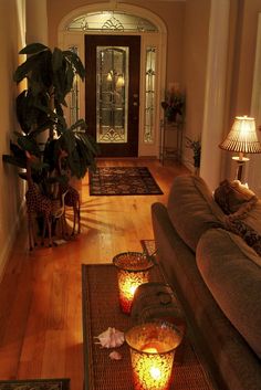 a living room filled with furniture and a lamp on top of a wooden floor next to a doorway