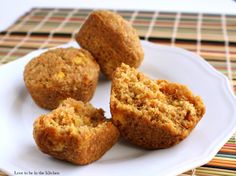 three muffins on a white plate sitting on a table