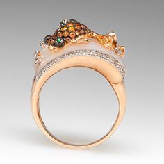 This beautifully fashioned whimsical ring is topped with mother of pearl and accented on the edges with a total of thirty-six (36) bead set round brilliant cut diamonds that are lined with milgrain details. The top of the ring features a black rhodium and rose gold fish, bead set with thirty-six (36) round brilliant cut orange sapphires and eighteen (18) round brilliant cut, light yellow sapphires. The eyes are each bezel set with one (1) round modified brilliant cut tsavorite garnet. The mother Whimsical Ring, Fish Ring, Cut Orange, Tsavorite Garnet, Gold Fish, Bead Set, Orange Sapphire, Black Rhodium, Garnet Rings