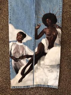 an altered pair of jeans with the image of two women sitting on top of clouds