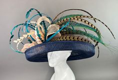 Navy Blue flipped brim hat adorned with peacock spines. Coordinated with shades of teal and turquoise feathers. Fits crown size of 22.5" with internal elastic band to create a snug and comfortable fit for crown sizes smaller than 22.5". Please measure prior to purchasing as all sales are final. Don't forget to follow us on Instagram @ TheHatHive Blue High Crown Hat With Adjustable Fit, Adjustable High Crown Blue Hat, Blue Adjustable High Crown Hat, Adjustable High Crown Blue Costume Hats And Headpieces, Adjustable Blue Fascinator With Feather Trim, Adjustable Blue Mini Hats With Feathers, Fitted Blue Hat With Feathers, Blue Feather Trim Hat For Races, Blue Feathered Hat For Races