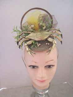 *  Wear this to 'glitz' any event.  This gold crab with a few scattered pearls will blend with any outfit.  The background and sides are filled with airy millinery netting which adds a little drama. * It looks complete all the way around as the back is important to see as well as the front. *  It has been designed so that most of the weight is directly on top of the head.  It is secure, well balanced and comfortable to wear. In addition, the metal headband will fit just about any head size.   * Gold Mini Hats For Summer Party, Gold Fascinator For Formal Summer Events, Gold Fascinator For Spring Evening, Gold Summer Formal Fascinator, Vintage Headpieces For Summer Formal Events, Vintage Gold Costume Hat For Weddings, Vintage Formal Headpieces For Summer, Vintage Summer Formal Headpieces, Vintage Formal Summer Headpieces