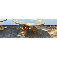 two wooden tables sitting next to each other on top of a cement floor covered ground