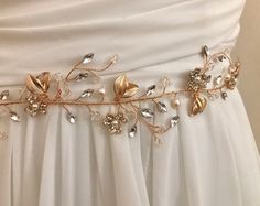 Whimsical nature, This delicate floral vine is hand wired with luminous pearls, sparkling crystals and delicate stamped gold metal leaves. Daintily rimming your waist, this bridal sash is eye catching and and very feminine.  READY TO SHIP DETAILS * Measures aprox. 1.75' wide (at widest part by 14" long. * Lightweight, flexible & very comfortable *  Attached at ends to imported  French satin ribbon in color choices * Offerend in gold * Total sash length is 3 yards View my complete collection incl Bridesmaid Belt, Crystal Wedding Tiaras, Pearl Wedding Dress, Flower Girl Accessories, Waist Jewelry, Gold Wedding Dress, Wedding Dress Sash, Vine Wedding, Wedding Belt