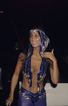 a woman dressed in blue and purple posing for the camera