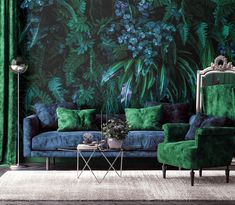 a living room with green velvet furniture and large wallpapered plants on the walls