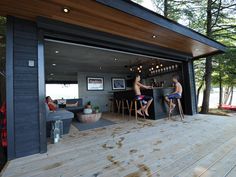 two people sitting at a table in front of an open garage door on a deck