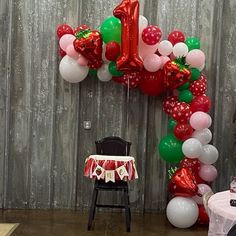 the balloon arch is decorated with red, white and green balloons