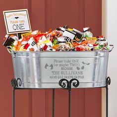 a metal tub filled with lots of candy sitting on top of a table next to a red door