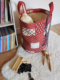 a red basket sitting on top of a white rug