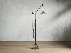 an old fashioned floor lamp in front of a concrete wall