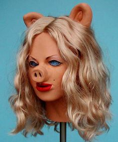 a mannequin head with blonde hair and blue eyes is wearing a pig mask