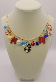 This charm necklace is made with an Italian solid 14k gold over 925 sterling silver paperclip chain. Length: 20 inches long. It holds 13 primarily red, white, blue, yellow, and pink charms of varying sizes and shapes lending to its eclectic feel. This necklace would suit any teacher and/or school personnel looking to jazz up their back-to-school outfits. Charms: Lucky, backpack, confetti ball, A+, pearl, good, paint palette, apple, blue gemstone, 100, blue confetti call, right angle, best award. Multicolor Personalized Pendant Charm Necklaces, Personalized Multicolor Pendant Charm Necklaces, Personalized Multicolor Pendant Charm Necklace, Multicolor Paperclip Chain Jewelry For Gifts, Multicolor Paperclip Chain Necklace As Gift, Multicolor Paperclip Chain Necklace Gift, Multicolor Paperclip Chain Necklace For Gift, Pink Charms, Blue Confetti