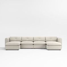 a white sectional couch sitting on top of a white floor