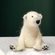 a white stuffed polar bear sitting on top of snow