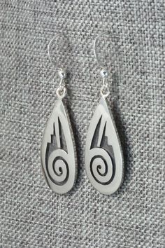 These sterling silver earrings are made by Hopi silversmith Timothy Mowa. The backs are signed and stamped sterling.Length: 1 5/8"Width: 1/2"Free shipping on all orders! We ship with USPS and always include tracking. All orders ship within a day of payment.Returns are accepted up to 30 days after you receive your order. Just send us a message. Our shop offers cash back or store credit. The item must be returned in new condition. Silver Symbolic Engraved Earrings, Silver Engraved Symbolic Earrings, Engraved Teardrop Sterling Silver Earrings, Symbolic Engraved Silver Earrings, Silver Engraved Teardrop Earrings, White Sterling Silver Earrings Stamped 925, Silver Southwestern Style Earrings For Gifting, Silver Southwestern Earrings For Gift, Silver Southwestern Style Earrings For Gift