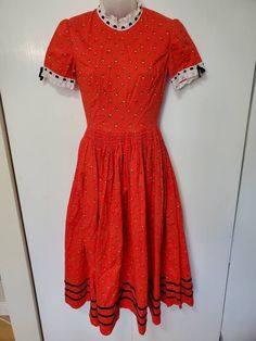 "Amazing handmade vintage dress from the 60's/70's! No labels.gr Red floral fabric with lace accents and velvet ribbon.  Maxi length. Zipper in back. Smocking on Waist- some is coming undone. In Great Vintage Condition - rip in underarm has been repaired. Measurements: Bust: 34\" Waist: 26\" Hips: free Shoulders: 14\" Length: 46\"" Fitted Red Smock Dress, Vintage Smocked Fitted Dress, Fitted Smock Vintage Dress, Fitted Vintage Smock Dress, Vintage Cotton Dress With Smocked Bodice, Vintage Short Sleeve Smock Dress, Vintage Smock Dress With Short Sleeves, Vintage Red Dress With Lace Trim, Red Vintage Dress With Lace Trim