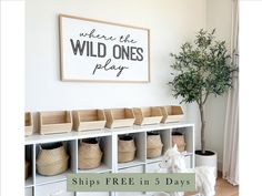 there is a white shelf with baskets on it and the words, where the wild ones play