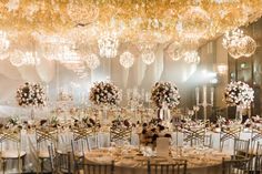 an elegant wedding reception with chandeliers and floral centerpieces