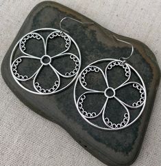 "These are so unique and cool! Big silver flower hoop earrings. They are modern and whimsical. Eye catching and versatile. Dress them up or down. The earrings measure 1 3/8\" long by 1 3/8\" wide and are made from plated silver. They hang from simple silver ear wire hooks. Overall drop length is 1 1/2\". I have a matching necklace in my shop if you would like the whole set. Here is a direct link Thanks for stopping by! Please take a moment and visit the rest of my Etsy store. I have many more un Silver Metal Flower Hoop Earrings, Nickel Free Hoop Earrings For Spring, Silver Flower-shaped Metal Hoop Earrings, Sterling Silver Flower Hoop Earrings For Pierced Ears, Round Metal Flower Earrings With Ear Wire, Spring Silver Metal Hoop Earrings, Silver Whimsical Flower Earrings, Silver Metal Hoop Earrings For Spring, Silver Floral Hoop Earrings