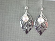 "silver leaf dangle earrings - white pearl accent - delicate lightweight You will find these in the wedding section in my shop The leaf is a light weight dainty silver plated charm and the bead is a man made shell pearl . These have been wire wrapped in silver colored non tarnishing craft wire These come on silver plated hypoallergenic ear wires. They dangle down 1 1/2\" from the top of the ear wire or 36 mm for my metric friends. Please see pic in hand for size reference. These come in a cute g Elegant Nickel-free Leaf-shaped Jewelry, Leaf-shaped Wedding Jewelry With Matching Earrings, Silver Leaf Earrings, Jewelry Delicate, Mismatched Bridesmaid Dresses, Pearl Bridal Jewelry, Pearl Bridal, Earrings White, Bridal Pearls