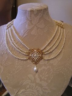 LIMITED ָָָָָָָָָ Beautiful Bridal choker features four strands of small cream Ivory pearls with a golden flower filigree set with Ivory pearls and a Swarovski drop pearl is dangle below.Between the lines of the pearls I connected the separate golden findings set with rhinestone. Its Ornate Pearl Drop Jewelry, Cream Pearl Pendant Necklace For Wedding, Cream Pearl Necklace With Pendant For Wedding, Elegant Silver Pearl Necklace With Intricate Design, Wedding Pearl Necklace With Multi-strand Pearl Chain, Multi-strand Pearl Necklace For Wedding, Classic Multi-strand Pearl Necklace For Wedding, Classic Multi-strand Wedding Jewelry, Classic Multi-strand Jewelry For Weddings