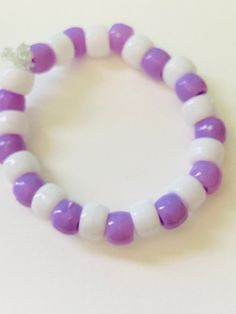 This is a cute Purple & White Bracelet. It really pops out. It's adorable! Cute Purple Friendship Bracelets For Birthday, Cute Purple Friendship Bracelet For Birthday, Cute White Plastic Jewelry, Cute White Bracelets For Party Favors, Cute Purple Hypoallergenic Bracelets, Cute Adjustable Plastic Stretch Bracelet, Playful White Plastic Jewelry, Playful White Bracelets For Party Favors, Cute Adjustable Purple Friendship Bracelets