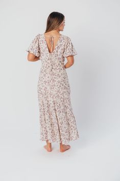 Discover effortless elegance in our charming Lucia Maxi Dress - it's already a favorite here at Worth Collective! This beautiful dress is cut on the bias, ensuring an ultra-flattering and feminine fit. The Lucia's puffed sleeves and flowy skirt only add to its vintage allure, and its gorgeous lilac floral print is spring-ready! Pair with pumps or dainty sandals for an extra-special event. FIT: Runs true to size. Fabric does not stretch; bias cut makes this dress more fitted through the waist and Beach Maxi Dress With Puff Sleeves, Feminine Fitted Maxi Dress For Brunch, Casual Maxi Dress With Fitted Bodice And Short Sleeves, Short Sleeve Maxi Dress With Tie Back For Brunch, Tie Back Midi Dress With Fitted Bodice For Brunch, Fitted Ditsy Floral Print Maxi Dress, Fitted Sundress Maxi Dress With Gathered Neckline, Fitted Sundress With Gathered Neckline, Feminine Fitted Maxi Dress With Tie Back