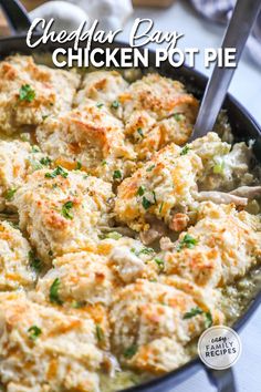 cheesy chicken pot pie in a cast iron skillet with a serving spoon