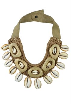 The Twine and Twig Cowrie Collar is designed using natural string and pineapple leaf fibers woven with cowrie shells and carved resin pieces. Each Collar is hand tied onto our signature branded suede straps. The necklace features two length options with a brass snap closure. Tied onto a pair of Taupe suede straps. Twine & Twig jewelry may have slight variations and natural imperfections enhancing its raw, handcrafted look. Each necklace has slight natural variations in shell size and color hue. Artisan Adjustable Natural Necklaces, Artisan Adjustable Natural Color Necklaces, Artisan Adjustable Natural Necklace, Unique Beach Jewelry With Adjustable Cord, Summer Vacation Braided Jewelry, Traditional Cowrie Shell Jewelry For Beach, Brown Beach Necklace With Adjustable Cord, Beach Necklace With Adjustable Cord In Natural Color, Natural Cowrie Shell Jewelry For Festivals