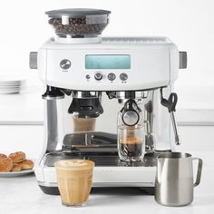 an espresso machine sitting on top of a counter next to a plate of food